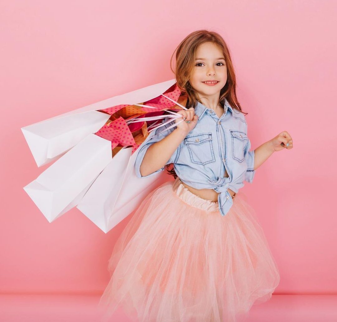 amazing cute little girl with long brunette hair walking with white packages isolated pink background little happiness expressing true positive emotions camera place text 197531 25295 e1724085217727